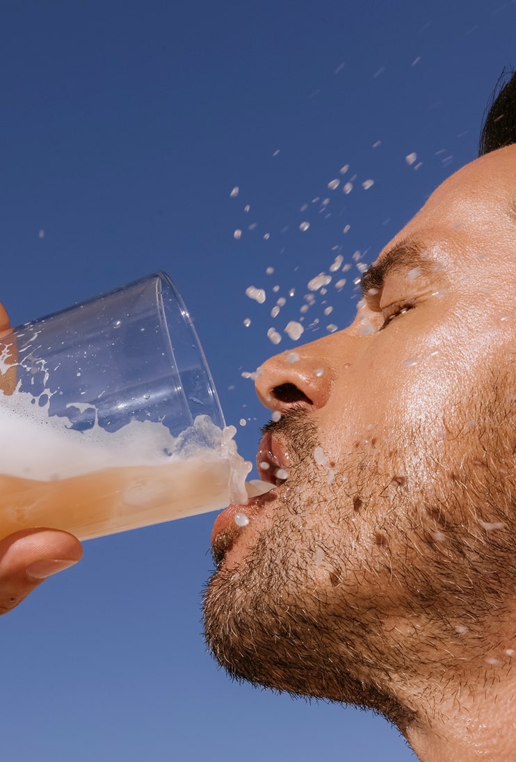 A man with a beard drinking peach persimmon ARMRA