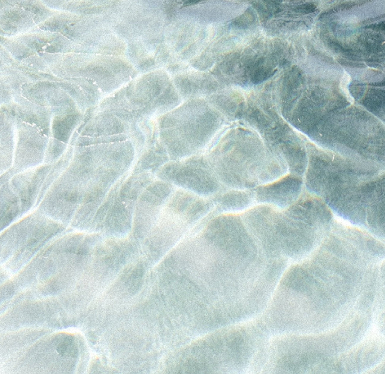 Light blue water image taken from above with light movement being seen in the water